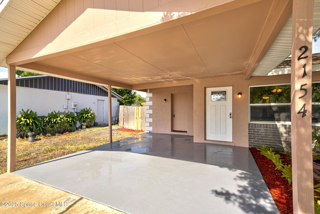 view of patio featuring fence and a carport