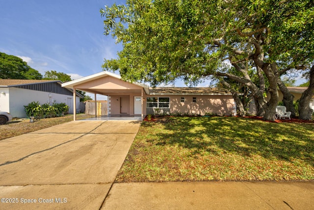 single story home with a front lawn, fence, driveway, and a carport