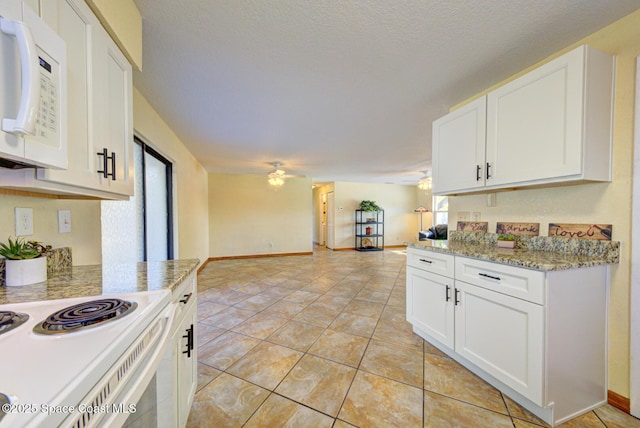 kitchen featuring white appliances, a ceiling fan, white cabinets, and open floor plan