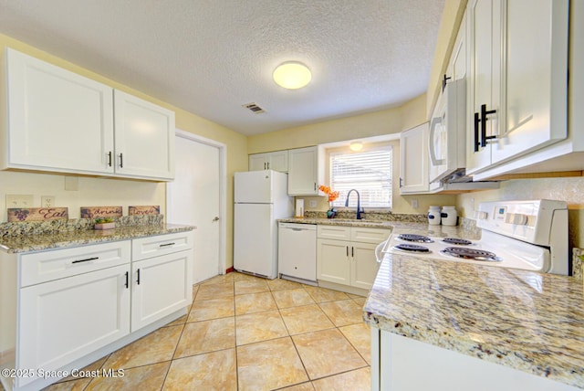 kitchen featuring light stone counters, a sink, white appliances, white cabinetry, and visible vents