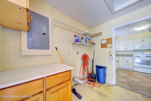 laundry area with a textured ceiling, light floors, laundry area, and electric panel