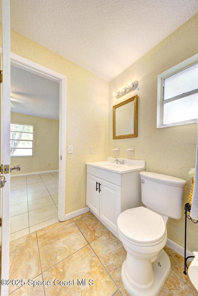 bathroom featuring tile patterned floors, vanity, toilet, and a textured ceiling