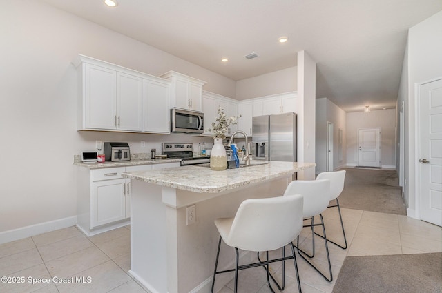 kitchen with visible vents, appliances with stainless steel finishes, light tile patterned floors, and white cabinets