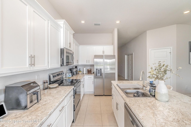 kitchen with a sink, stainless steel appliances, white cabinetry, recessed lighting, and visible vents