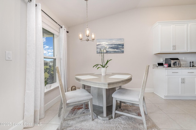 dining area featuring baseboards, a chandelier, light tile patterned floors, and lofted ceiling
