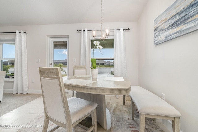 dining space featuring baseboards, a notable chandelier, and plenty of natural light