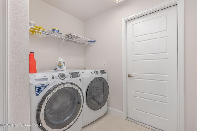 washroom featuring laundry area, baseboards, light tile patterned floors, and separate washer and dryer