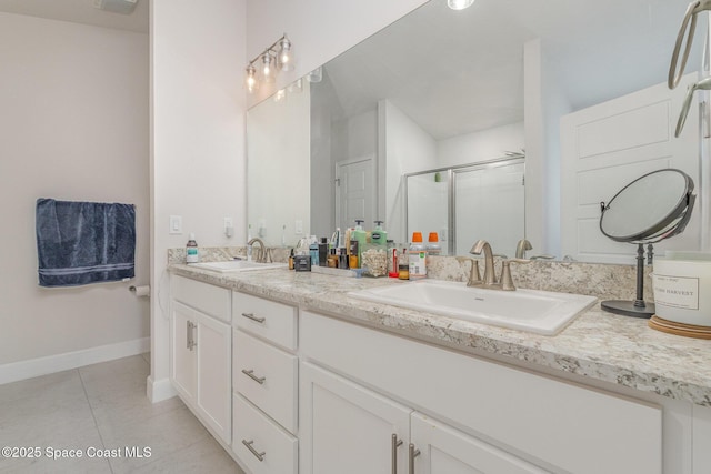 bathroom featuring double vanity, a sink, tile patterned floors, and a shower stall