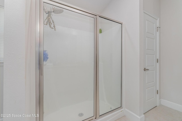 full bathroom with baseboards and a shower stall