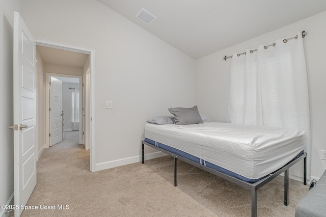 bedroom featuring light colored carpet, baseboards, lofted ceiling, and visible vents