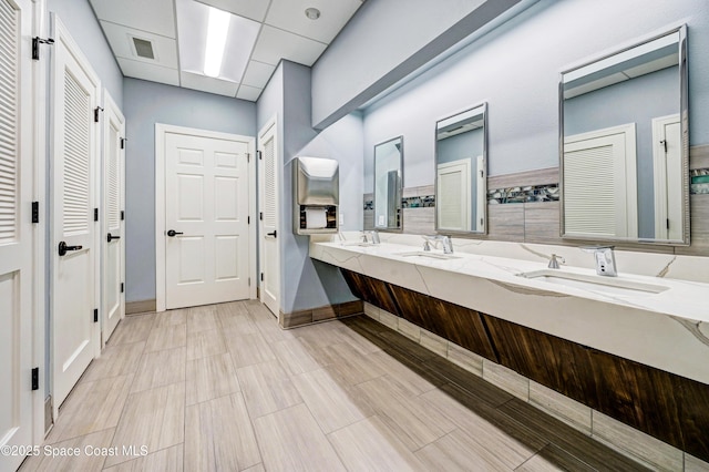 full bath featuring a closet, a sink, double vanity, and visible vents