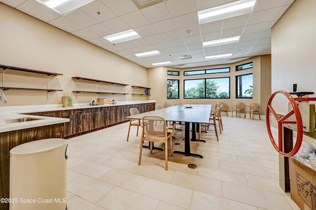 dining space with light tile patterned floors, a drop ceiling, and visible vents