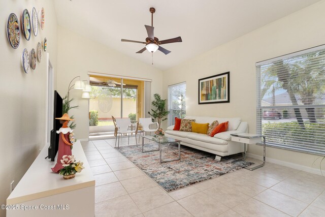 living room featuring tile patterned flooring, a ceiling fan, lofted ceiling, and baseboards