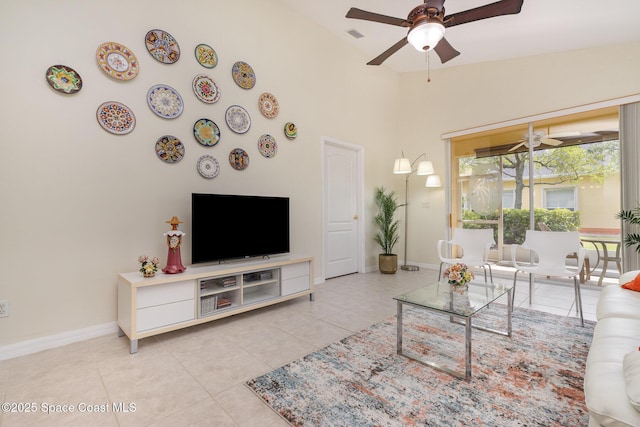 living room featuring light tile patterned flooring, ceiling fan, vaulted ceiling, and baseboards