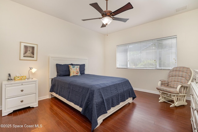bedroom featuring dark wood finished floors, baseboards, visible vents, and ceiling fan