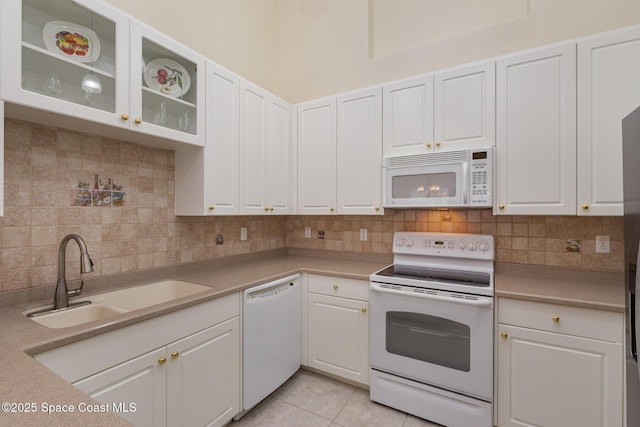 kitchen featuring a sink, white appliances, tasteful backsplash, light countertops, and white cabinets