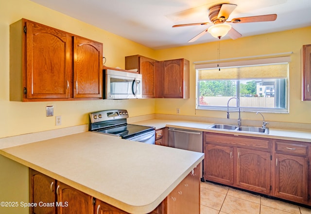 836 Brow Ct NE, Palm Bay, FL 32905 - kitchen with light tile patterned floors, appliances with stainless steel finishes, light countertops, brown cabinets, and a sink