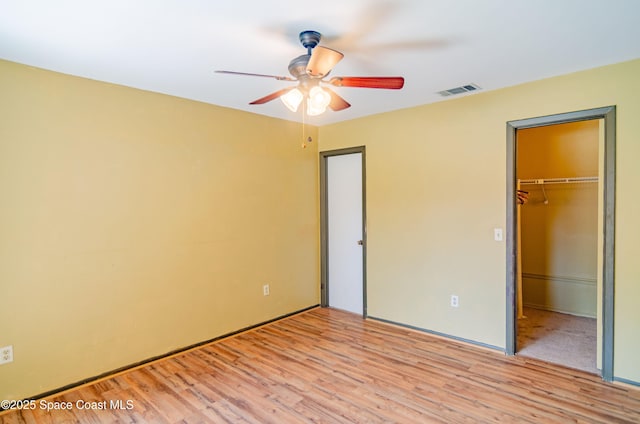 836 Brow Ct NE, Palm Bay, FL 32905 - unfurnished bedroom with visible vents, a closet, light wood finished floors, a spacious closet, and a ceiling fan