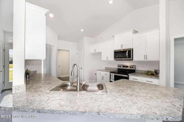 1822 San Filippo Dr SE, Palm Bay, FL 32909 - kitchen with white cabinets, a sink, stainless steel appliances, vaulted ceiling, and a peninsula