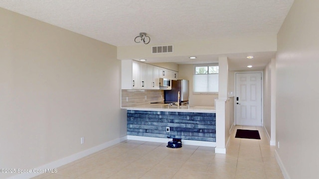 300 Columbia Dr Unit 203-2, Cape Canaveral, FL 32920 - unfurnished living room with light tile patterned floors, baseboards, a textured ceiling, and recessed lighting