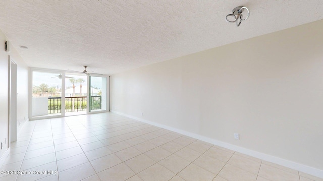 300 Columbia Dr Unit 203-2, Cape Canaveral, FL 32920 - unfurnished room featuring ceiling fan, light tile patterned flooring, baseboards, and a textured ceiling