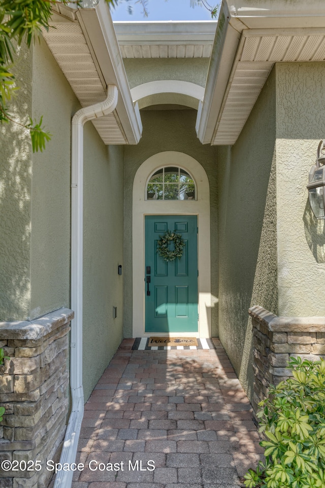 entrance to property featuring stucco siding