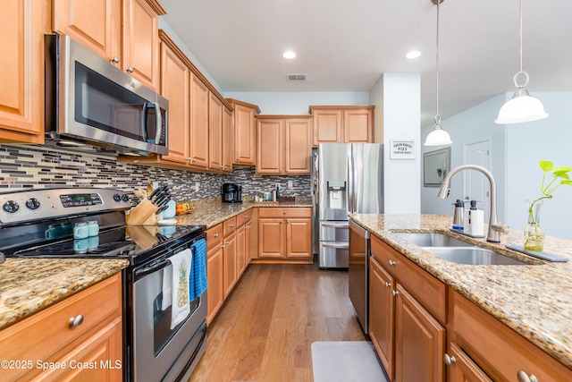kitchen with visible vents, tasteful backsplash, wood finished floors, a sink, and stainless steel appliances