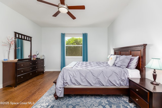 bedroom featuring baseboards, a ceiling fan, and wood finished floors