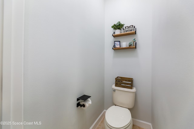 bathroom with baseboards and toilet