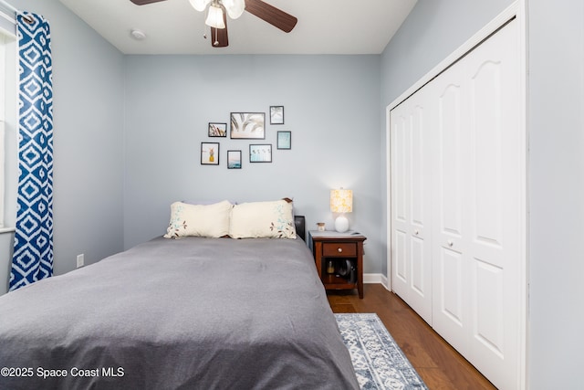 bedroom featuring a ceiling fan, a closet, and dark wood-style floors