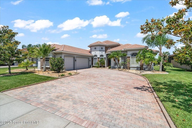mediterranean / spanish-style home with a garage, a tiled roof, a front lawn, and decorative driveway