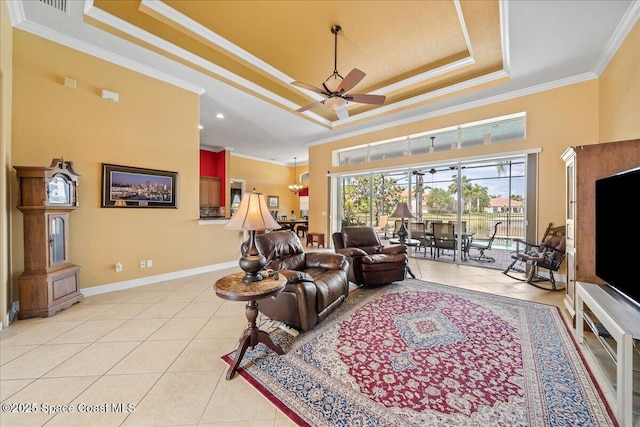 living room featuring ceiling fan, baseboards, light tile patterned floors, a tray ceiling, and ornamental molding