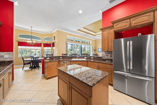 kitchen featuring crown molding, an inviting chandelier, stainless steel appliances, and a peninsula