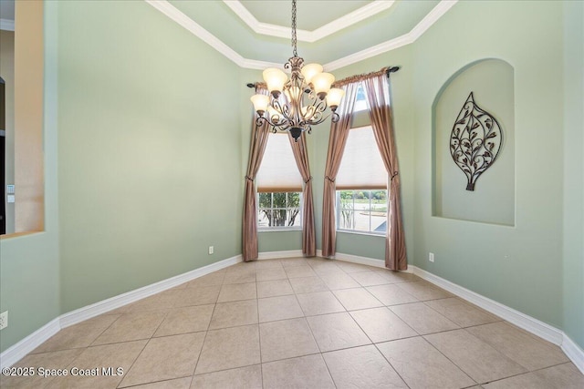 tiled spare room featuring a tray ceiling, an inviting chandelier, ornamental molding, and a healthy amount of sunlight