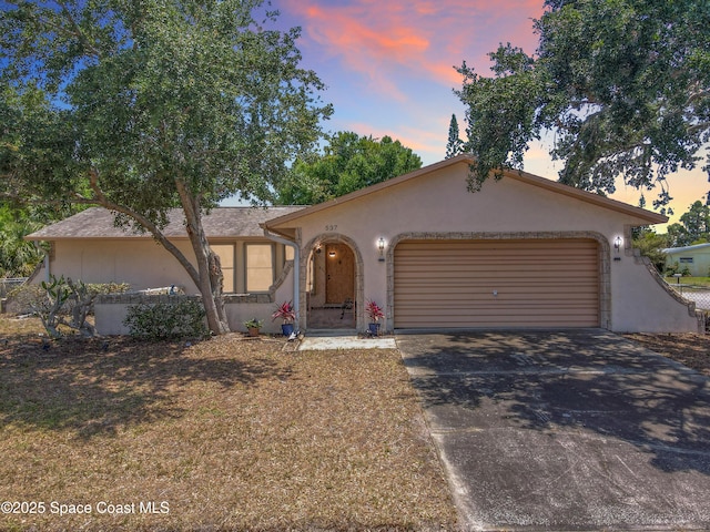 537 Ebony St, Melbourne, FL 32935 - view of front of house with stucco siding, a garage, and concrete driveway
