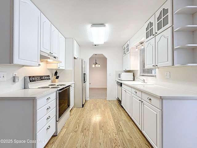 537 Ebony St, Melbourne, FL 32935 - kitchen featuring white appliances, under cabinet range hood, light wood finished floors, open shelves, and white cabinetry