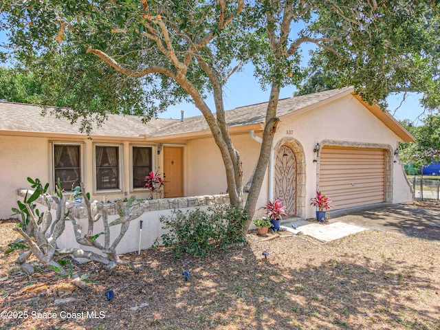 537 Ebony St, Melbourne, FL 32935 - ranch-style home featuring stucco siding, driveway, a garage, and roof with shingles