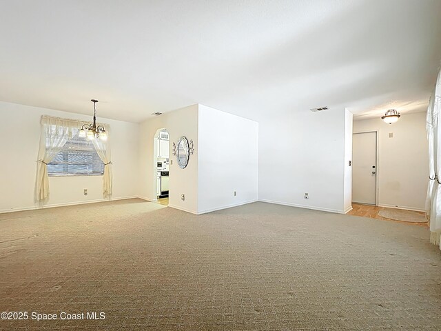 537 Ebony St, Melbourne, FL 32935 - spare room with a chandelier, baseboards, and carpet