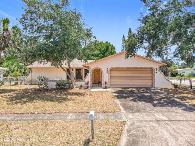 537 Ebony St, Melbourne, FL 32935 - view of front of property with stucco siding, a garage, and concrete driveway