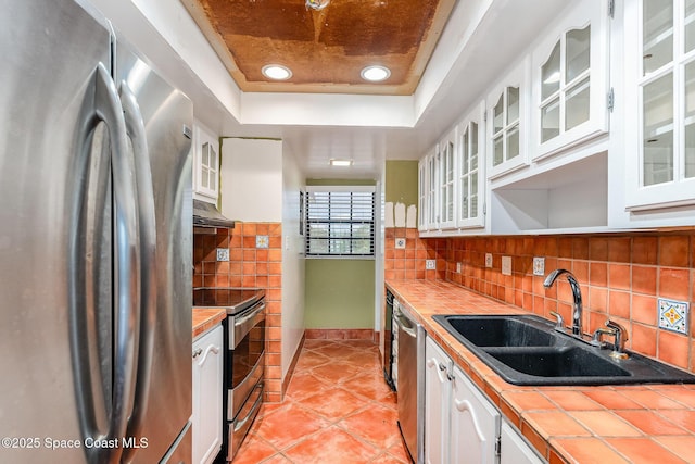 1025 Rockledge Dr Unit 502A, Rockledge, FL 32955 - kitchen with appliances with stainless steel finishes, tile countertops, a sink, a tray ceiling, and white cabinetry