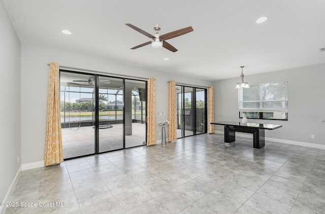 interior space with light tile patterned floors, visible vents, baseboards, recessed lighting, and ceiling fan with notable chandelier