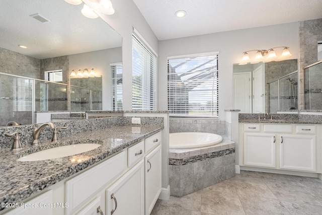 full bath with visible vents, a wealth of natural light, a shower stall, and a sink