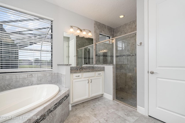 bathroom with a garden tub, a shower stall, tile patterned flooring, and vanity