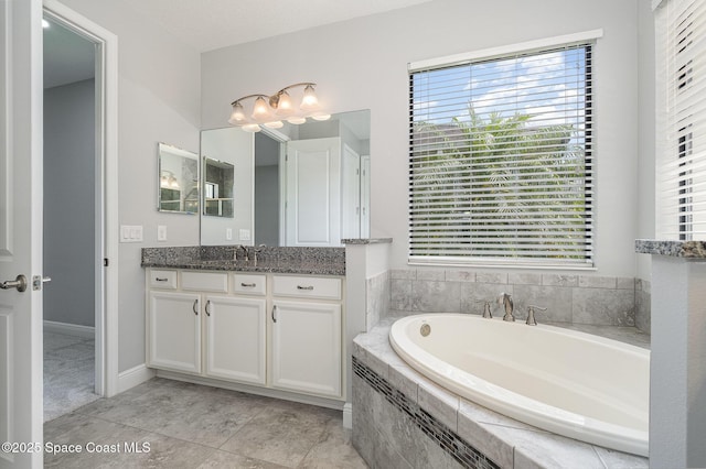 bathroom with an inviting chandelier, a wealth of natural light, a bath, and vanity