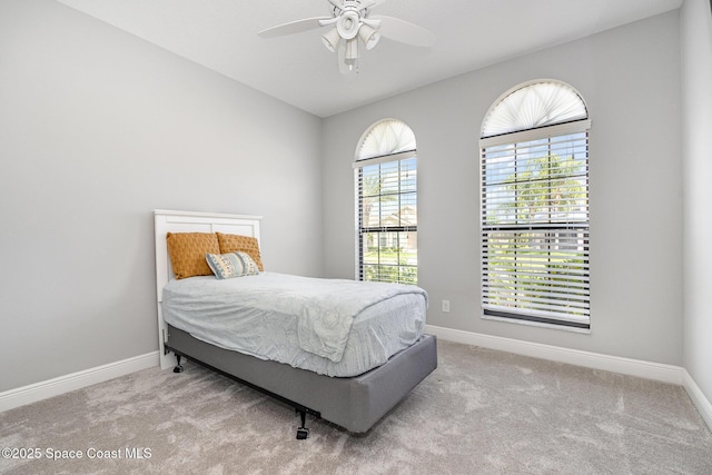 carpeted bedroom with a ceiling fan and baseboards