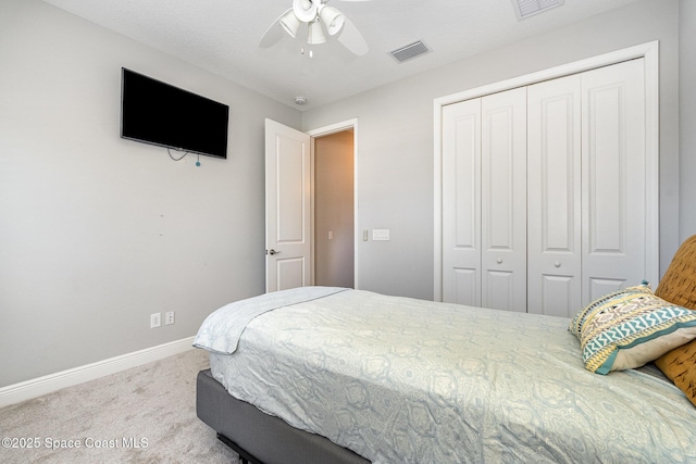 carpeted bedroom featuring a closet, visible vents, ceiling fan, and baseboards