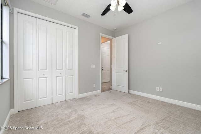 unfurnished bedroom featuring baseboards, visible vents, carpet, and a closet