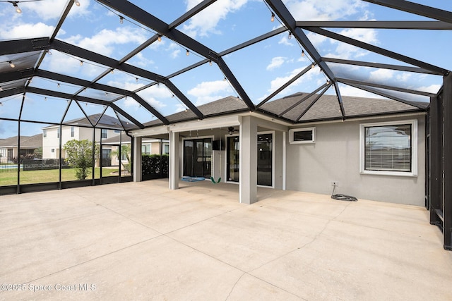 view of patio with ceiling fan and glass enclosure