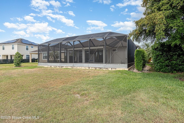 back of property featuring a yard and glass enclosure