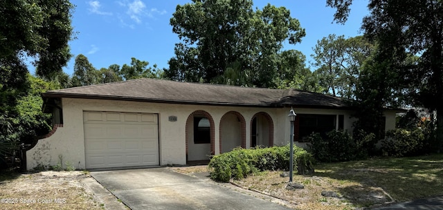 single story home featuring concrete driveway, an attached garage, and stucco siding